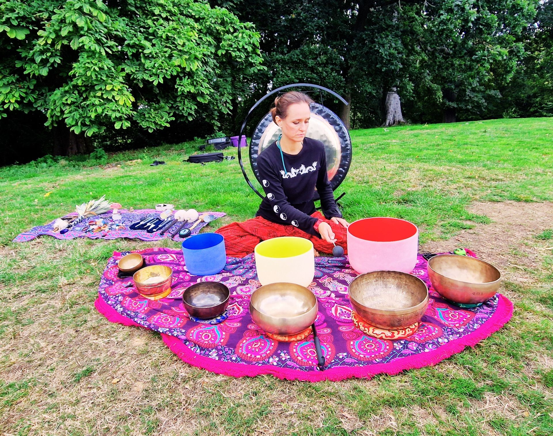 a sound healer playing tibetan and crystal bowls