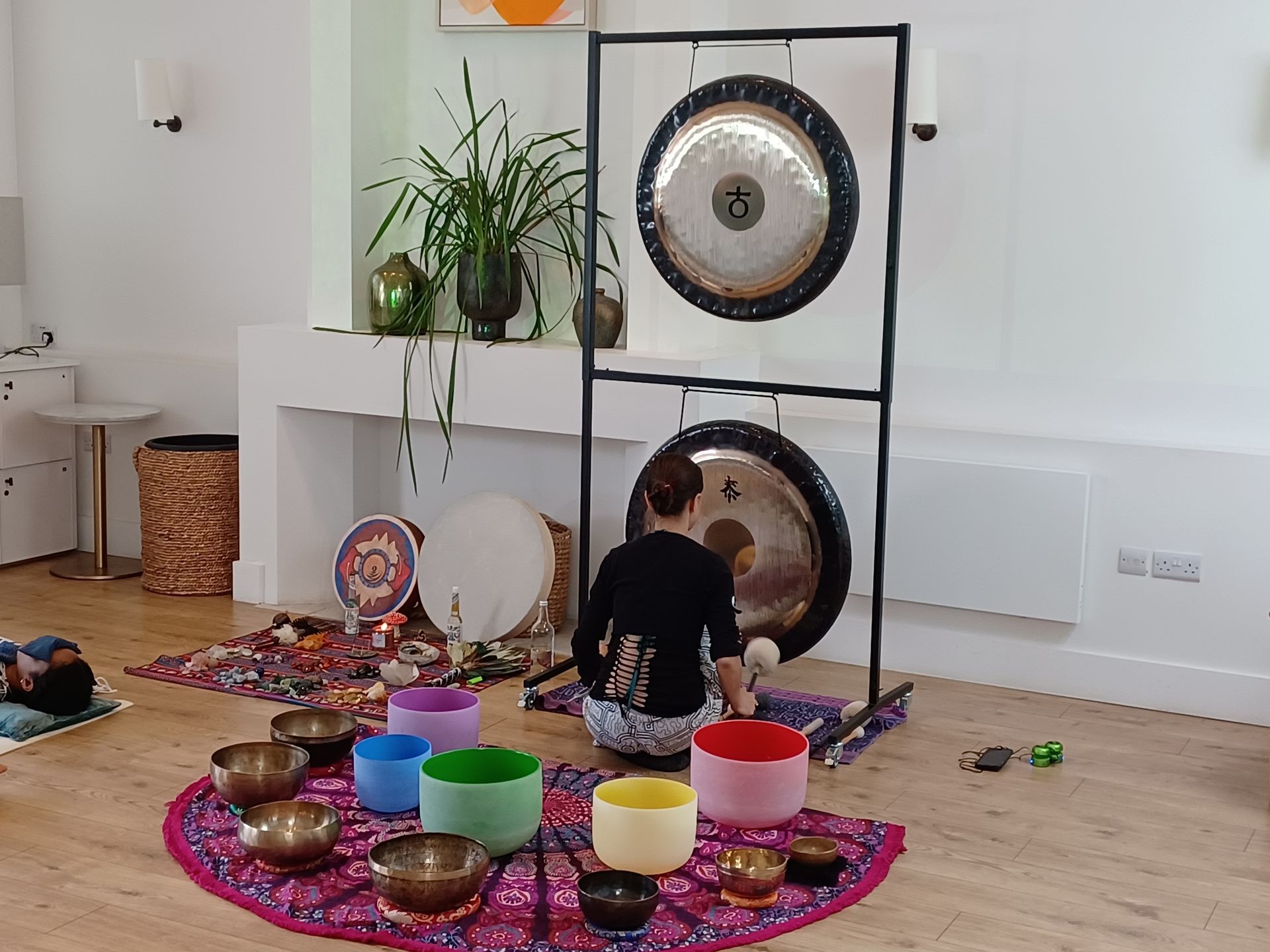 woman playing gong in a sound bath